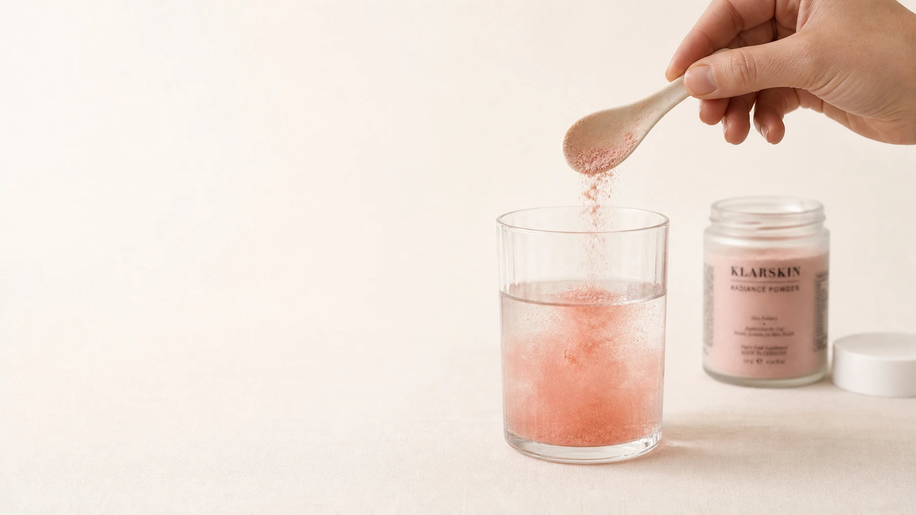 Hand gießt klarskin Radiance Powder in ein Glas Wasser – tägliches Ritual